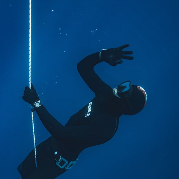 Apnéiste tenant le câble et regardant vers la surface dans la lumière de la rade de Villefranche-sur-Mer, sérénité