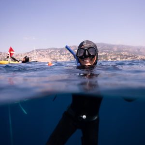Apnéiste souriante en surface dans la rade de Villefranche-sur-Mer après une plongée, ambiance bien-être et sérénité, nice, une véritable odyssée
